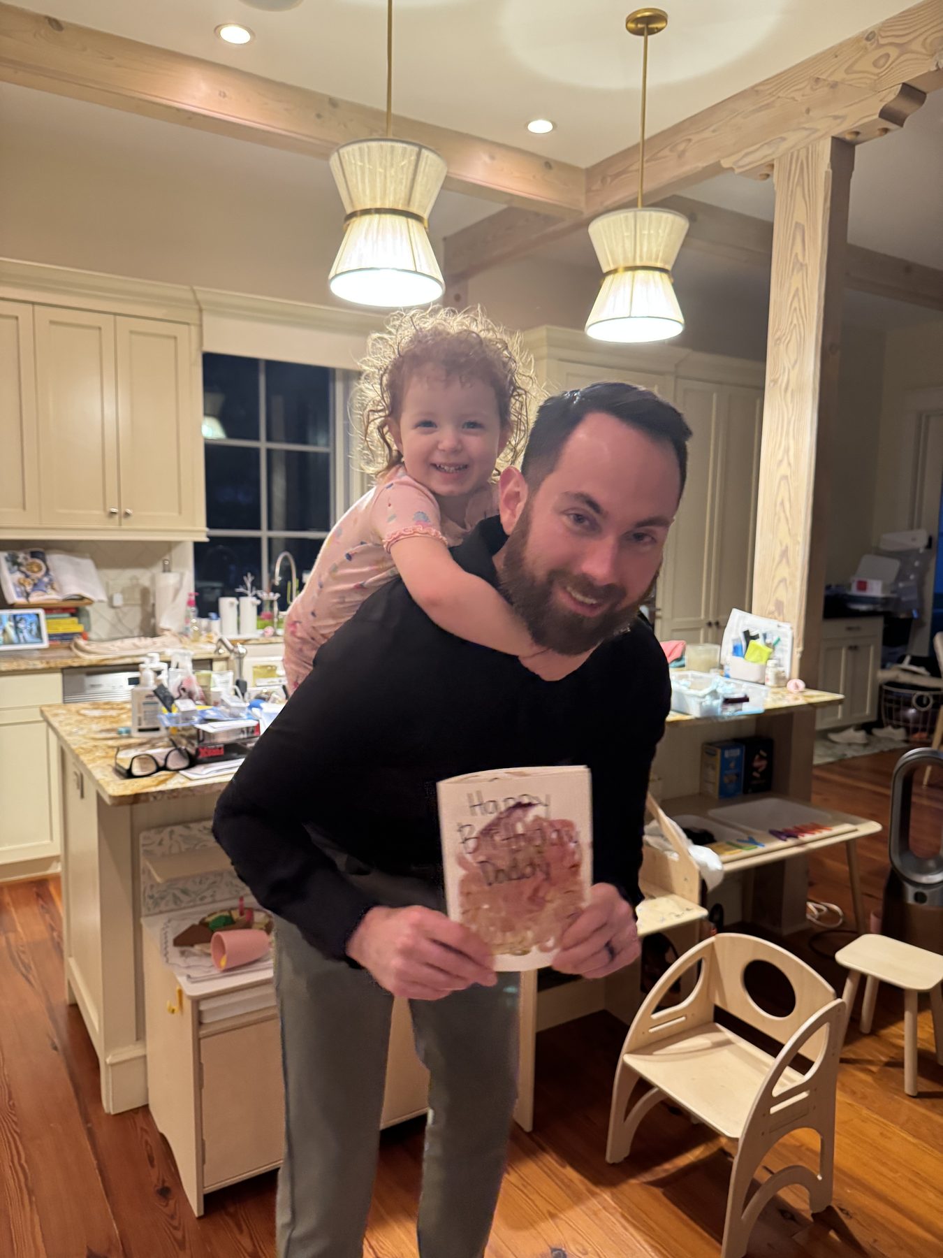 Jesse Plunkett holding his younger daughter in their kitchen