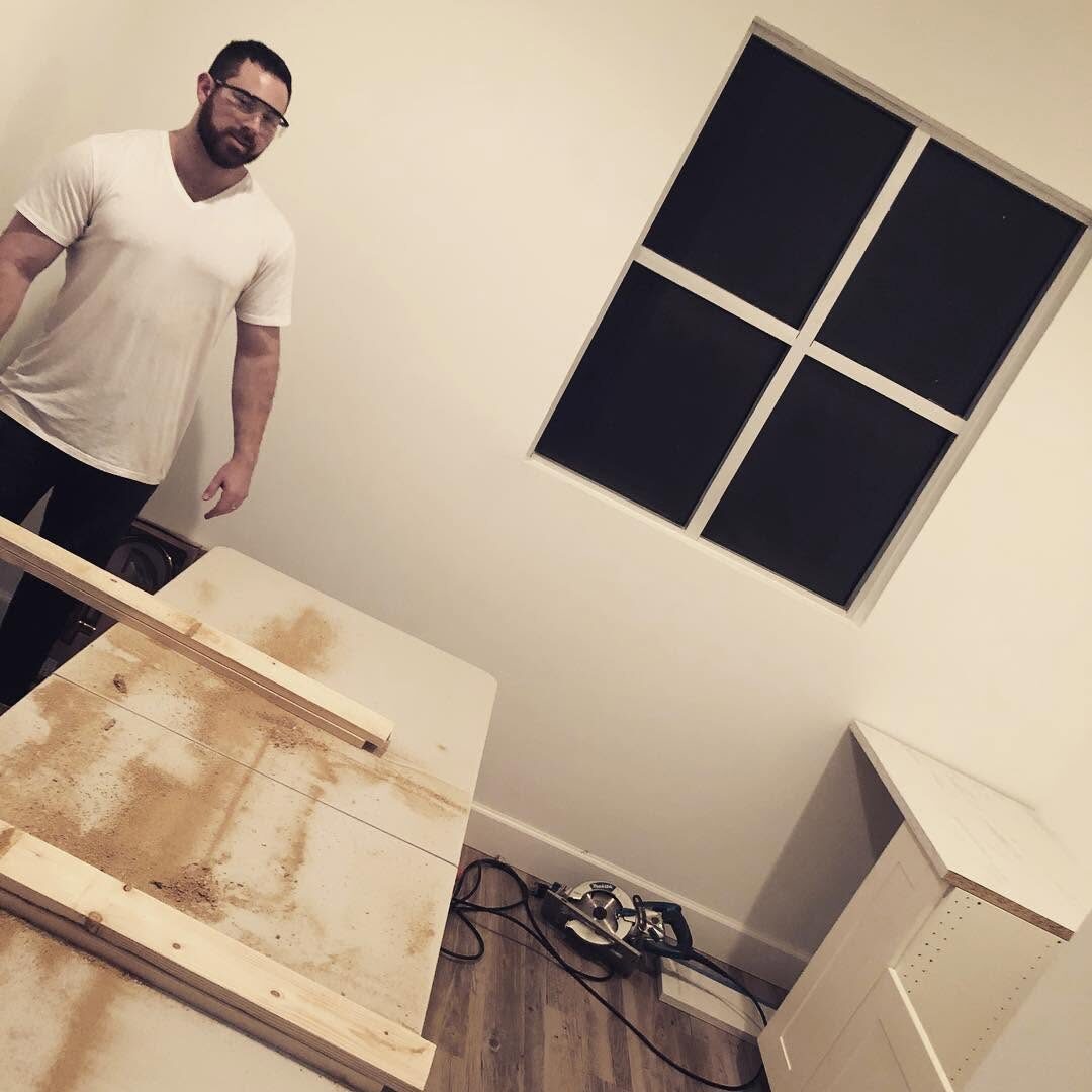 Jesse Plunkett in safety glasses during an early med spa buildout, surrounded by lumber and tools